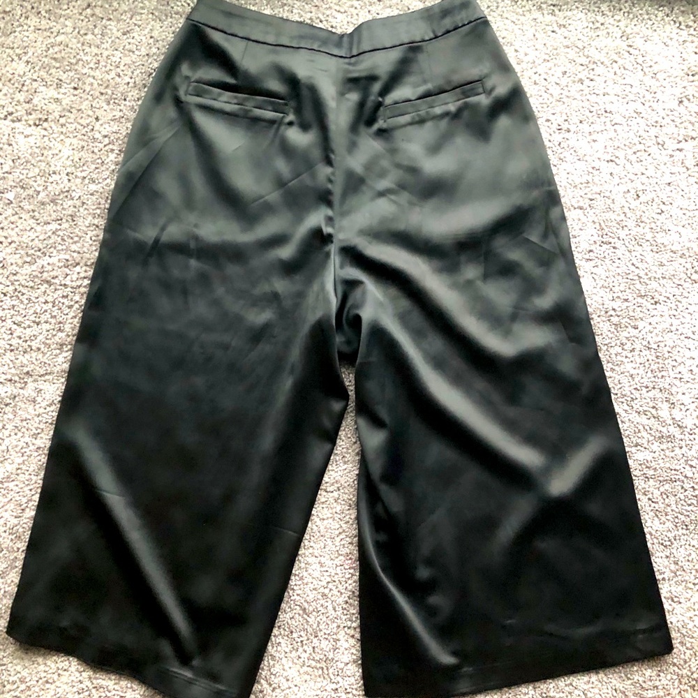 Short black silk trousers.